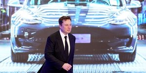 Elon Musk, patron de Tesla, devant un écran montrant une Tesla Model 3, lors de la cérémonie d'ouverture du programme Model Y de Tesla en Chine à Shanghai