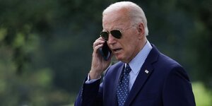 Le president americain joe biden parle au telephone dans le jardin de la maison blanche