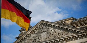 Un drapeau allemand flotte devant le batiment du reichstag a berlin, allemagne