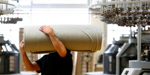Un employe deplace des draperies dans l'usine de l'entreprise textile "trigema" a burladingen